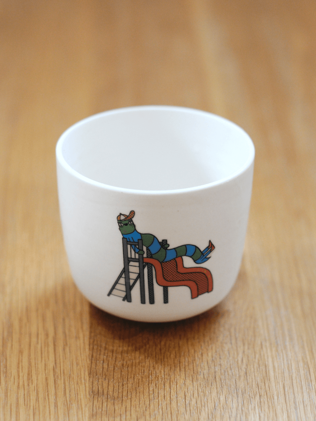 כוס עם דקאל של תולעת בפארק משחקים