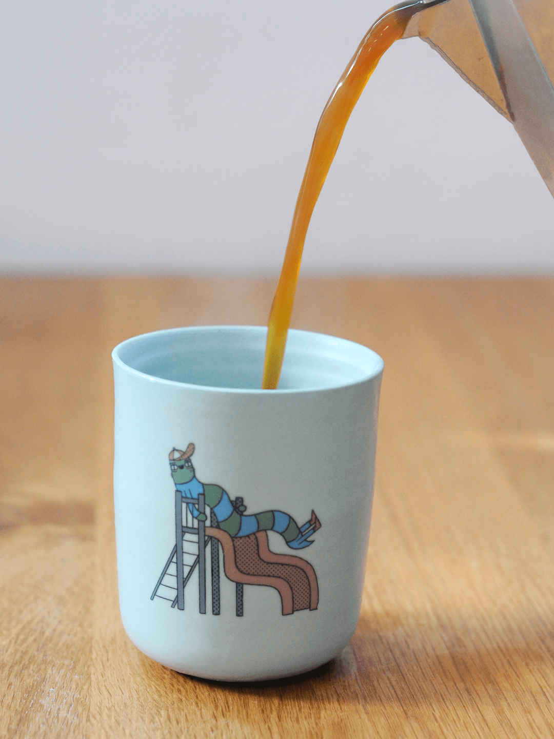 כוס עם דקאל של תולעת בפארק משחקים